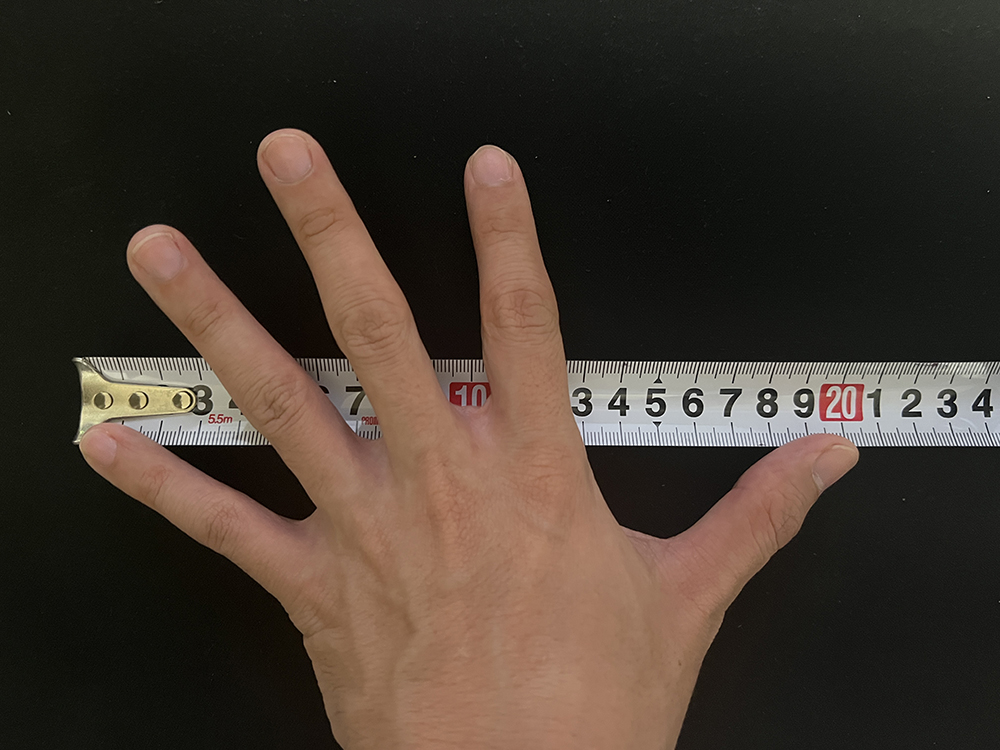 男性の手を広げた状態で親指の先から小指の先までを測った結果は約20cm